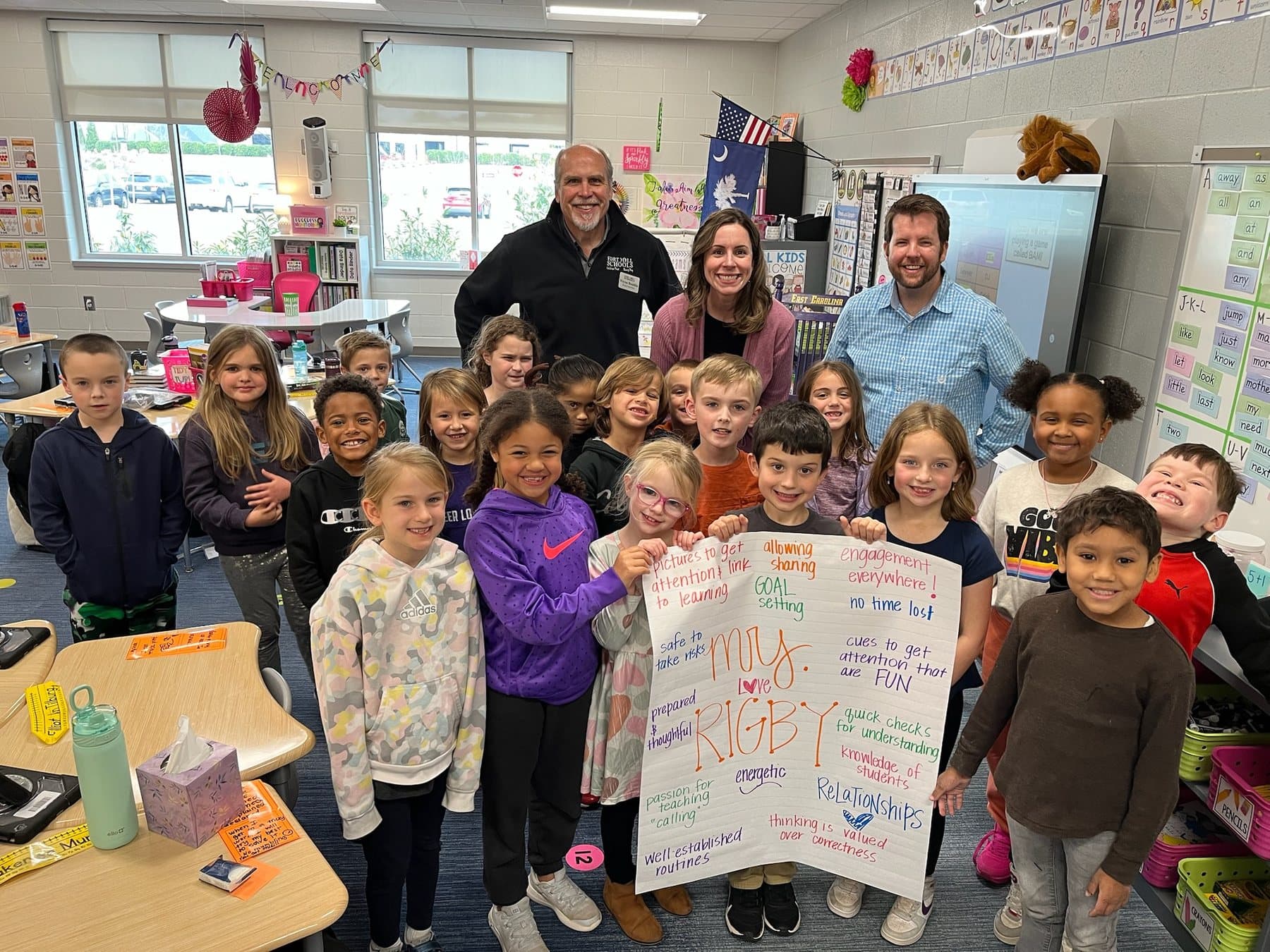 Joe Helms standing at the back of a Fort Mill elementary classroom with a teacher and her full class of students.